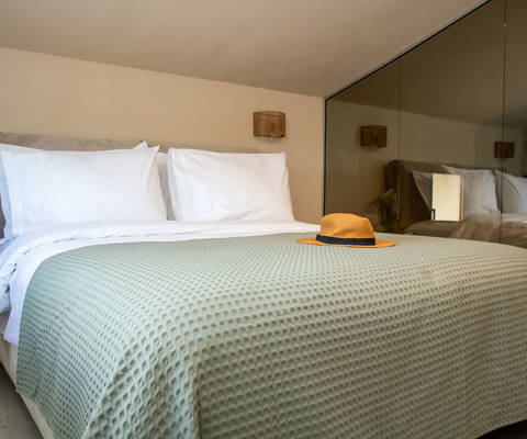 Cozy loft bedroom with double bed and bathroom with mirrored glass walls