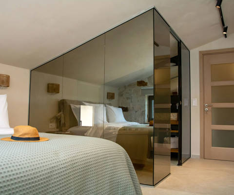 Modern bedroom with double bed, glass-walled shower and minimalistic decor