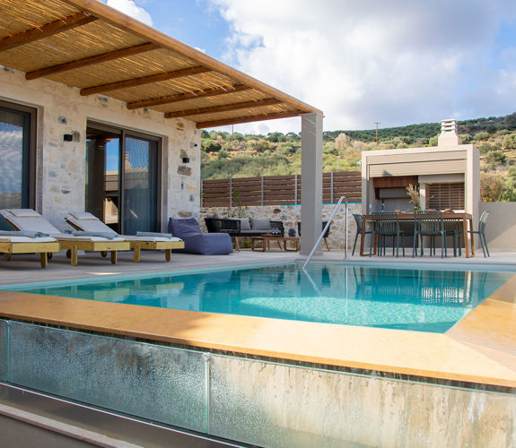 Outdoor pool area, having a dining table, a comfortable siting room and sunbeds, pool view